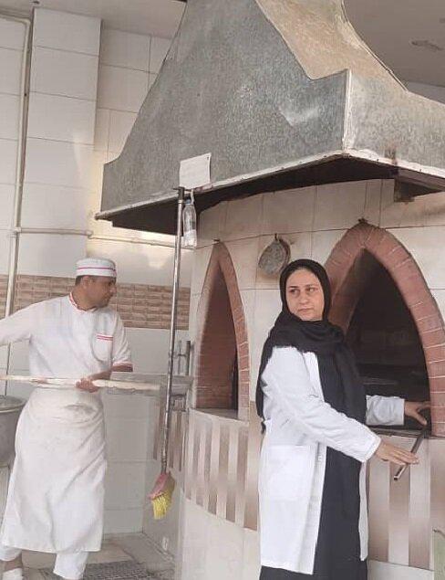 بانویی که پای تنور در کنار همسرش می ایستد