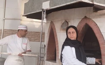 بانویی که پای تنور در کنار همسرش می ایستد